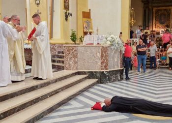 Dom Denis prostrato a terra durante la preghiera di consacrazione